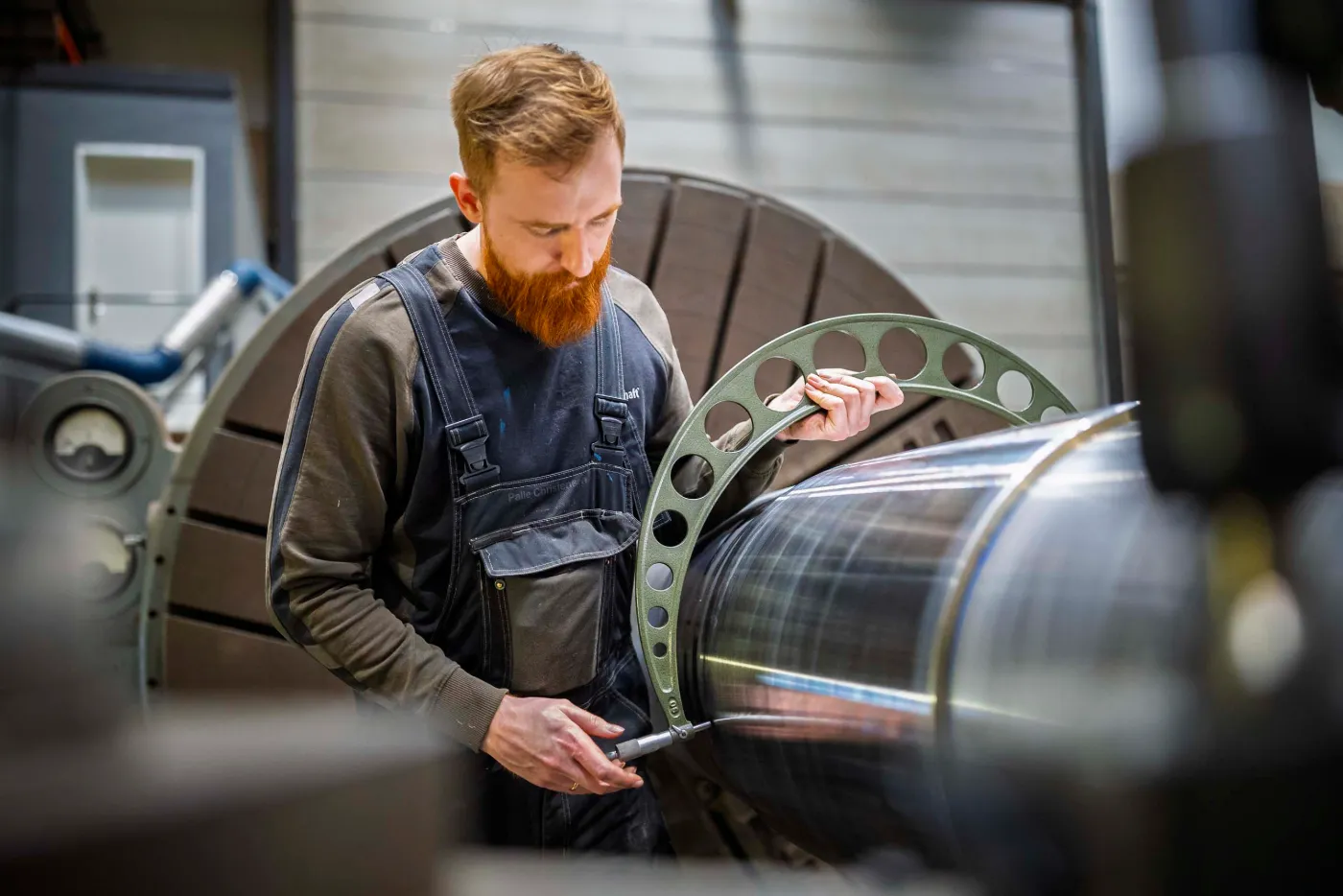 MarineShaft technician measuring a propeller shaft flange in the workshop